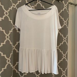 Flowing white shirt with ruffle hem